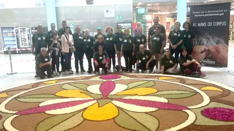 Los alfombristas y autoridades posan ante la alfombra.