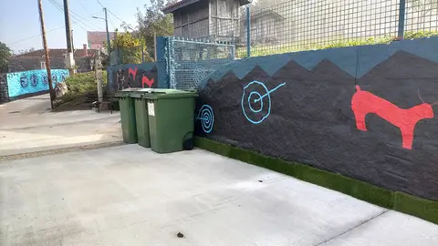 A arte de Xulio Fontes en Forxán, oculta detrás dos contedores, agarda pola visibilidade que merece no espazo público.
