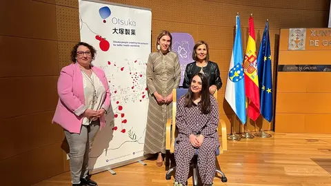 Nuria Carballeda, presidenta de la Asociación Galega de Lupus; Natalia Lobato, Secretaria General Técnica de la Consellería de Sanidade de la Xunta de Galicia; Montse Sánchez-Agustino, Regional Market Access Manager de Otsuka Pharmaceutical y sentada, Miriam Fernández, la conferenciante.