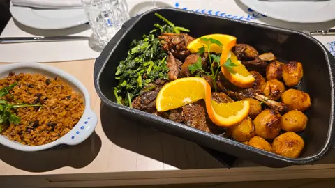 Cabrito al horno con patatas, grelos y arroz.