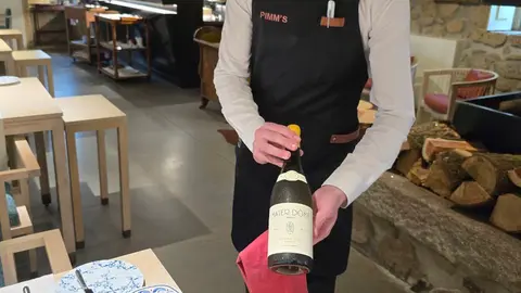 Rafael Carvalho muestra la botella de Douro blanco que armoniza con el Bacalhau com broa.