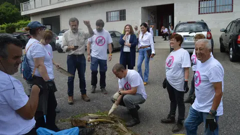 Voluntarios y autoridades de Mos, comprometidos en la limpieza del Rejo das Laxes, exhiben las bolsas repletas de residuos recogidos durante la campaña "1m² contra la basuraleza".