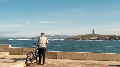 Un ciclista disfruta de las vistas de la Torre de Hércules en A Coruña.
