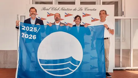 Orgullosos, los representantes del Náutico Coruñés sostienen las banderas Azul, de Calidad ("Q") y de Sostenibilidad ("S"), símbolos de su compromiso con la excelencia y el medio ambiente.