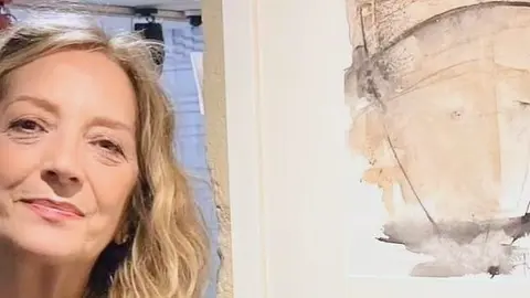 Julia Barreiro, la artista viguesa, posa junto a una de sus vibrantes acuarelas de la exposición "Versocromía", disponible en las Galerías Duran.