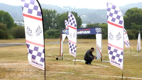 En el campo de vuelo de Quintela, los participantes del Campeonato de España de Drons de Carreiras se preparan para competir, con las banderolas marcando el circuito.