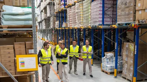 El conselleiro José González (izquierda), acompañado por el secretario general de Empleo, visita la nave de la empresa Distribuciones Rivas para conocer de primera mano el programa de Primera Experiencia Profesional.