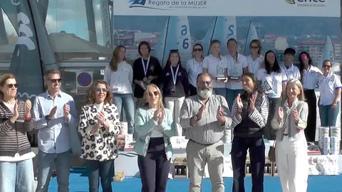 Foto de familia de autoridades y premiadas en el podio. © RFGV