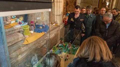 Asistentes a la inauguraci&oacute;n de la exposici&oacute;n 'Belenes del mundo' contemplan uno de los belenes expuestos en una de las vitrinas de la Catedral de Tui.