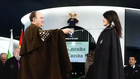 El Gran Comendador impone la capa a la conselleira Mar&iacute;a Mart&iacute;nez Allegue durante el acto de nombramiento de nuevos comendadores en la LVIII Feria del Cocido de Lal&iacute;n.