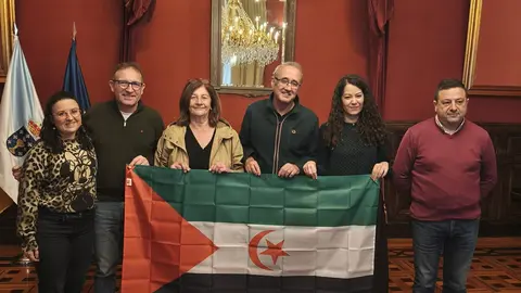Representantes del Fondo Galego de Cooperaci&oacute;n e Solidariedade y del Concello de Santiago posan con la bandera saharaui durante la reuni&oacute;n de la Comisi&oacute;n Ejecutiva celebrada en la capital gallega.