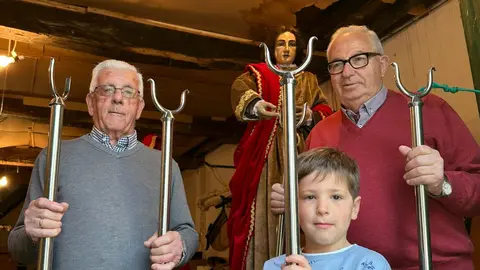 Tres generaciones de vecinos posan con varas procesionales junto a una imagen, reflejo del relevo y la continuidad de la tradici&oacute;n cofrade en la Casa de Novenas.
