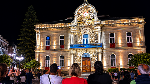 Vecinos y visitantes siguen la proyecci&oacute;n art&iacute;stica sobre el hist&oacute;rico edificio consistorial de Ponteareas durante una concurrida velada nocturna. A. OUTERELO.