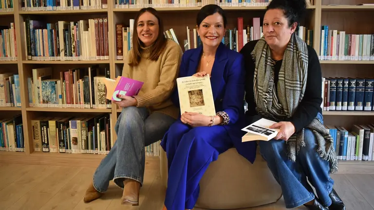 A alcaldesa de Mos, Nidia Arévalo, acompañada por dúas representantes municipais, durante a celebración do recoñecemento á Biblioteca María Magdalena.