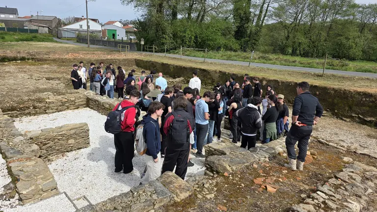 Estudantes do Grao en Historia seguen as explicaci&oacute;ns do equipo arqueol&oacute;xico nun percorrido polos restos romanos, evidenciando a magnitude do xacemento.