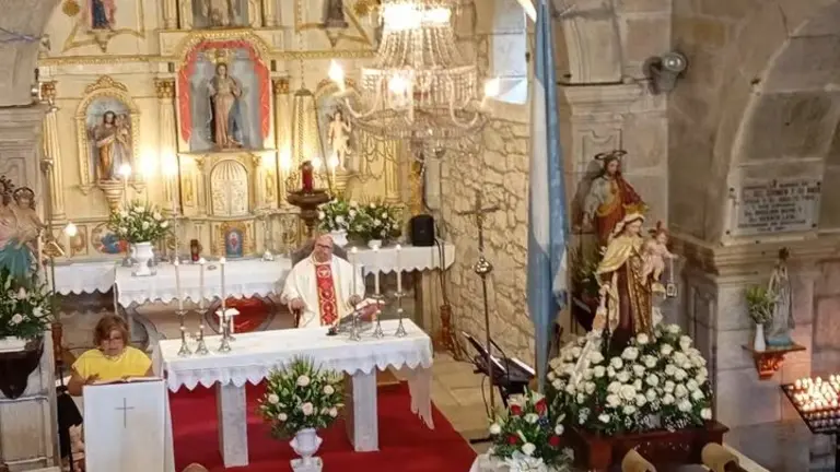 Interior da igrexa de Santa Mar&iacute;a de Para&ntilde;os durante unha celebraci&oacute;n relixiosa, co altar maior ao fondo e a imaxe da Virxe do Carme engalanada para a procesi&oacute;n, unha das devoci&oacute;ns con maior arraigamento na parroquia.