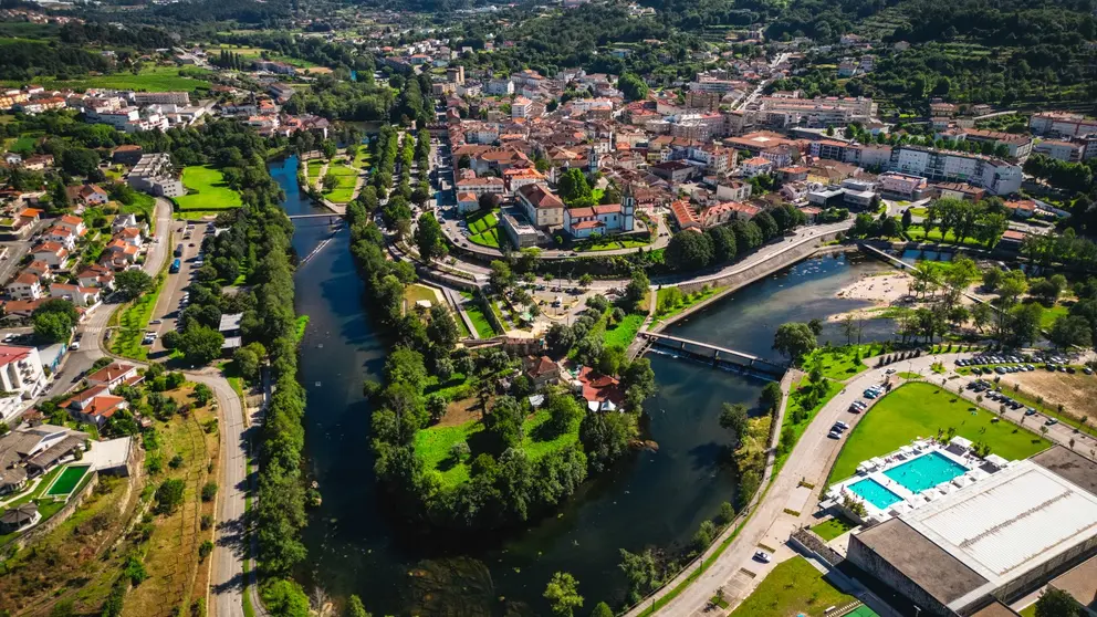 Vista a&eacute;rea de Arcos de Valdevez, com o centro urbano envolvido pelo rio Vez, evidenciando a integra&ccedil;&atilde;o entre patrim&oacute;nio, natureza e espa&ccedil;os de lazer no concelho.
