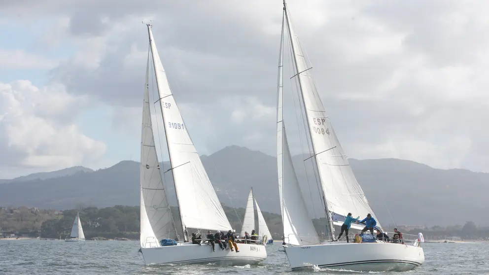 El Bon III y el ESP 10084 en plena maniobra durante la regata inaugural, con las R&iacute;as Baixas como tel&oacute;n de fondo.