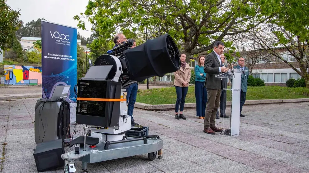 El conselleiro Rom&aacute;n Rodr&iacute;guez interviene durante la inauguraci&oacute;n de la infraestructura, junto al equipo investigador, con el sistema &oacute;ptico preparado para comunicaciones cu&aacute;nticas en primer plano.