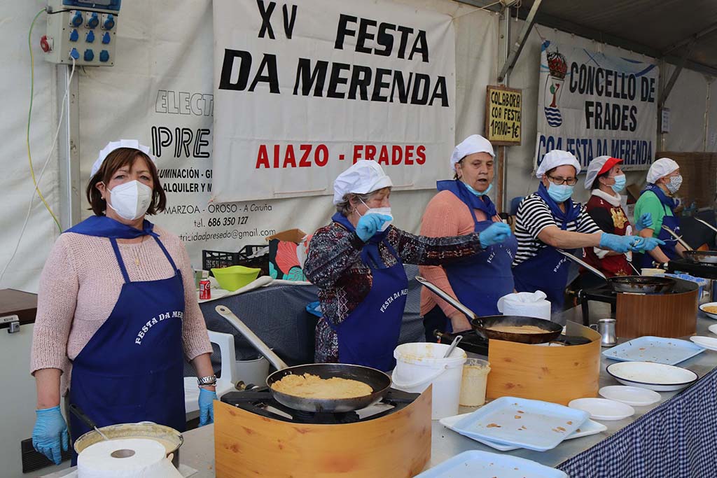 As cociñeiras traballando en quendas e con dúas filas para recoller as merendas gratuítas.