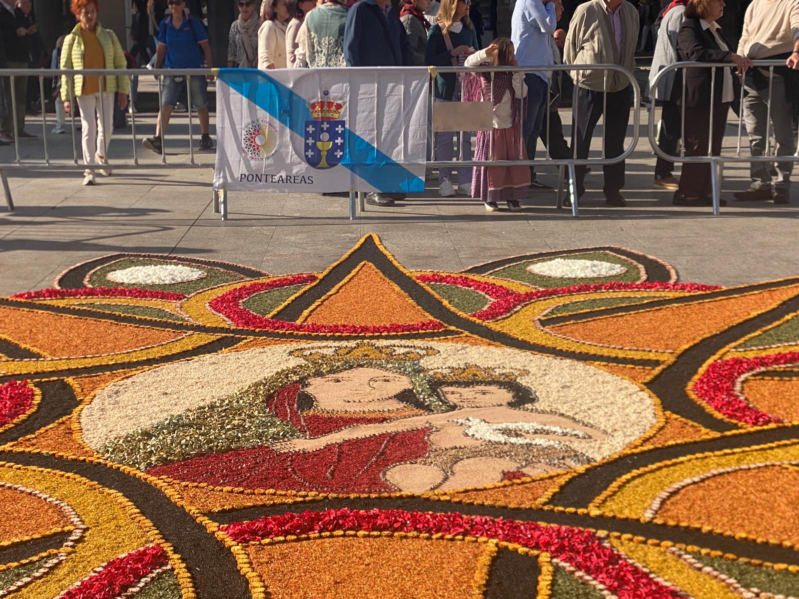 Arte y devoción: La estrella floral de los Alfombristas de Pontesreas en la Plaza del Pilar, con la Virgen y el Niño en el centro.