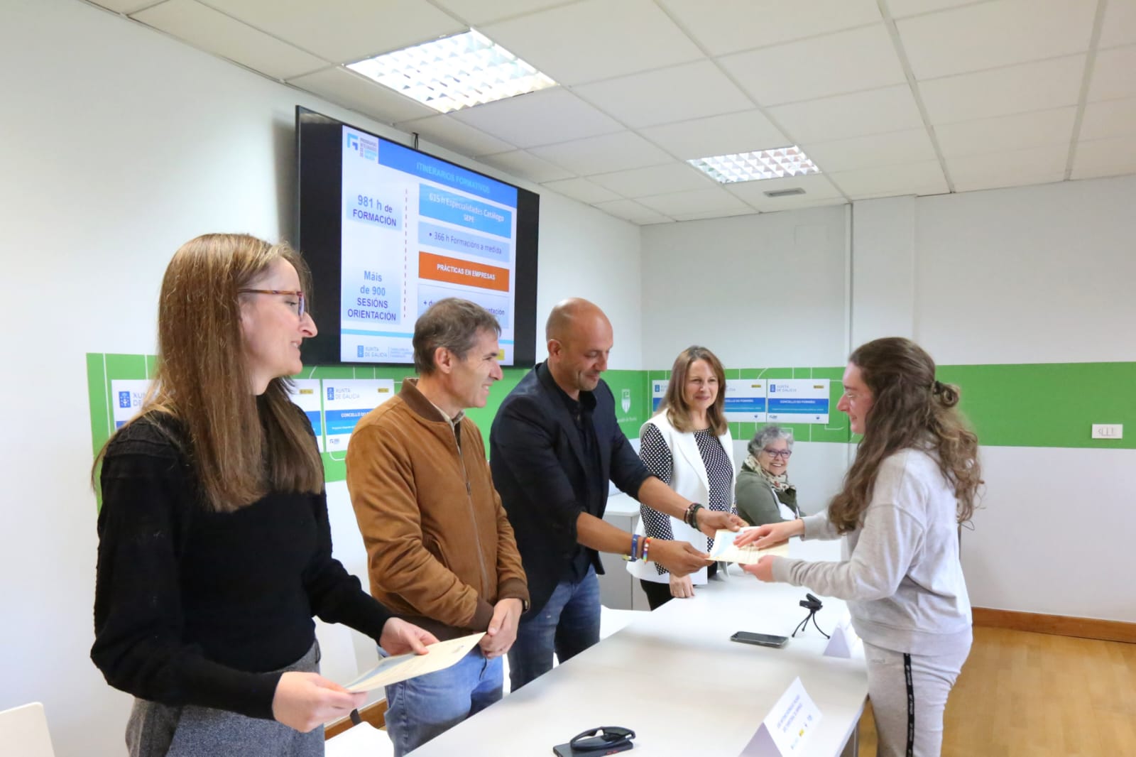 Una participante del Programa Integrado de Empleo de O Porriño recibe su diploma de manos del alcalde, Alejandro Lorenzo, durante el acto de clausura celebrado en el multiusos de Torneiros.