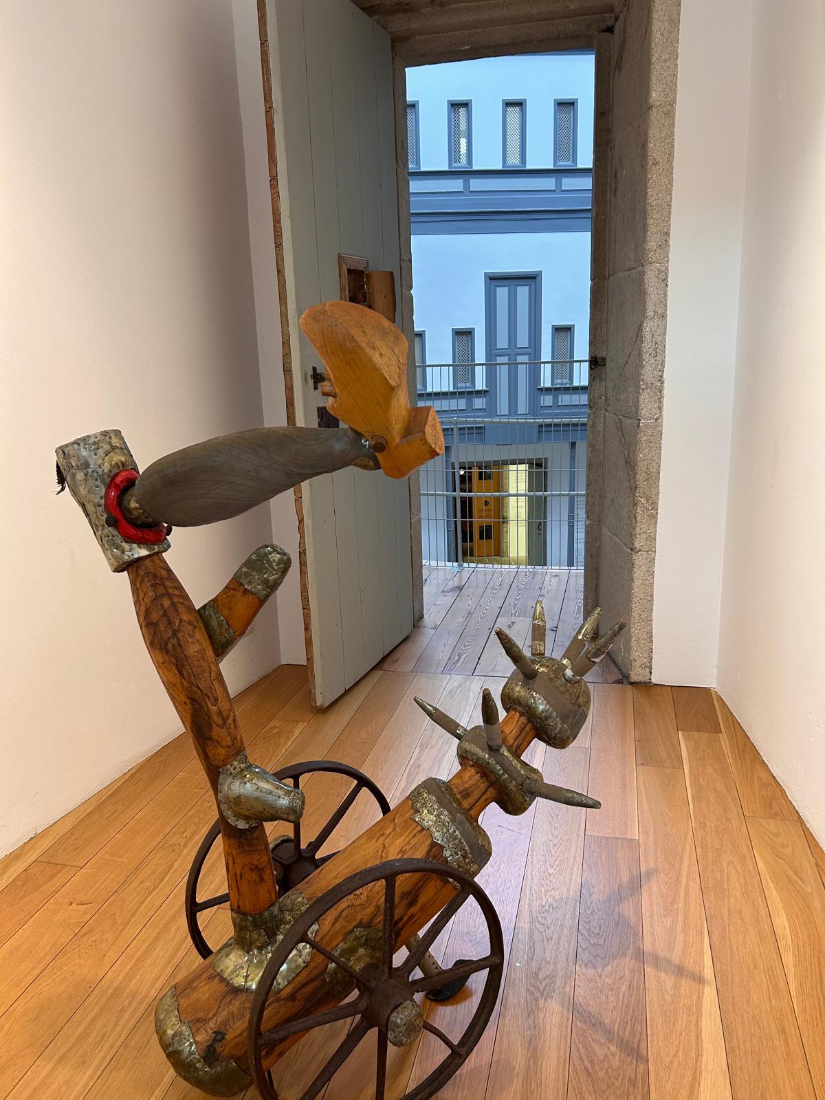 Escultura en madeira e ferro de Paco Pestana nun dos espazos interiores do Vello Cárcere, parte da mostra 'Paseando cariñosas alimañas'.