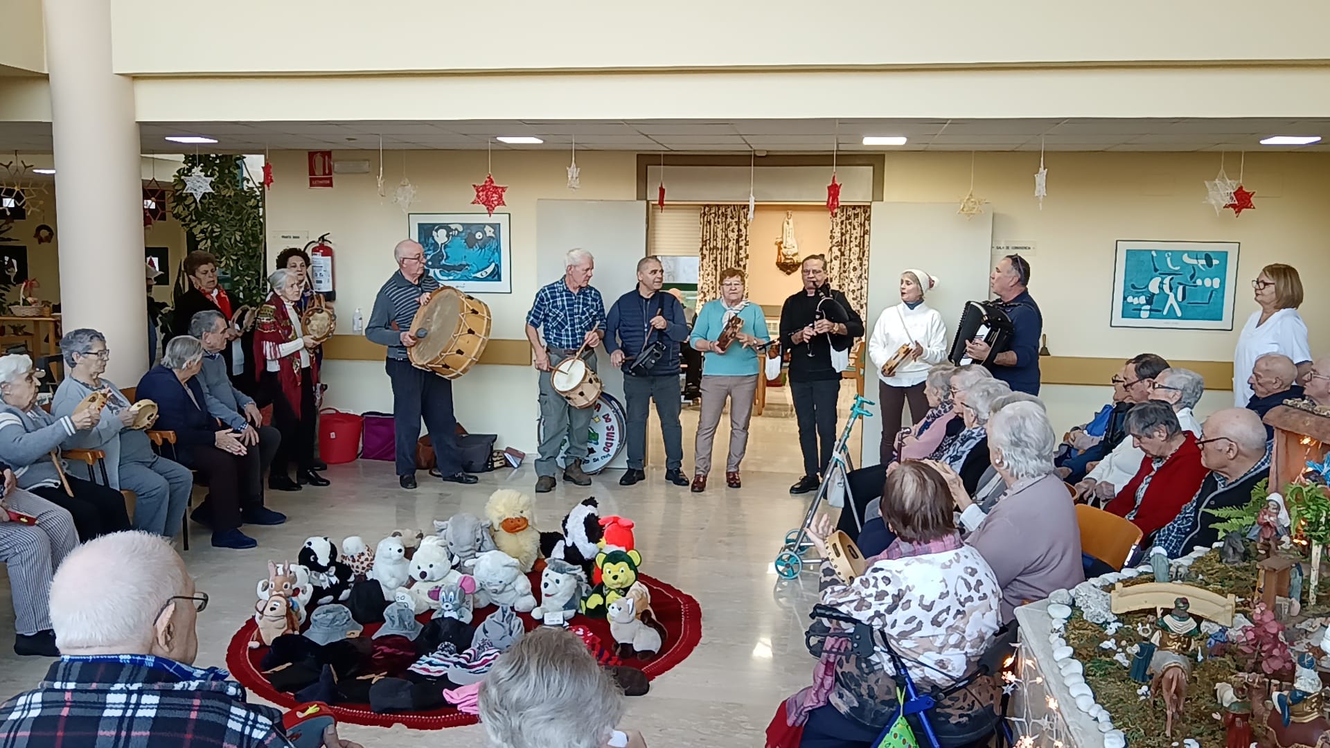Los mayores también participaron en la celebración, acompañando los villancicos con panderetas y palmas en un ambiente festivo y cercano.