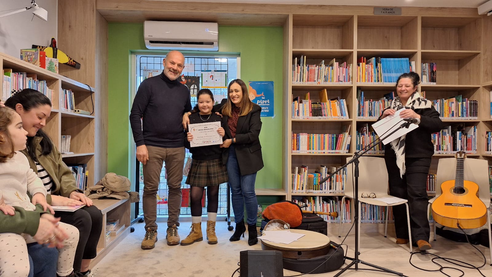 El teniente de alcalde, Camilo Grandal, y la concejala de Cultura, Sara Cebreiro, junto a una de las premiadas del Concurso de Postales de Navidad en la Biblioteca Municipal María Magdalena de Mos.