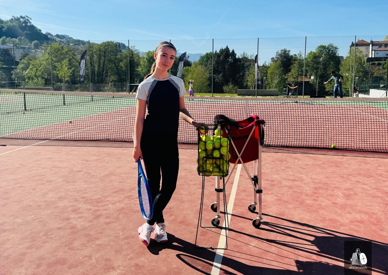 Una joven participante se prepara para los ejercicios de iniciación al tenis durante la jornada deportiva.