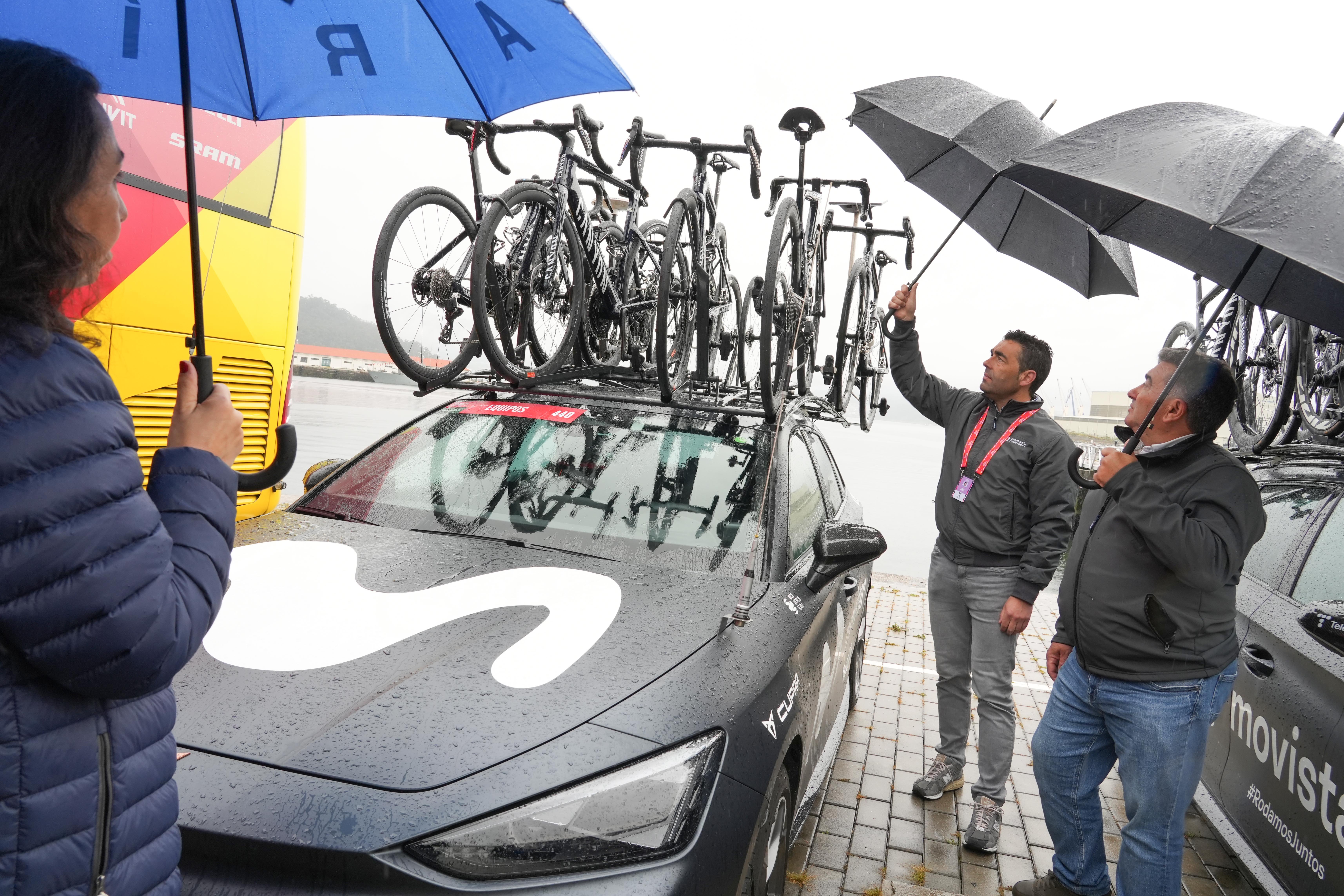 Luis López supervisa o dispositivo técnico da carreira baixo a choiva na saída de Marín, xunto a membros da organización e vehículos do equipo Movistar.