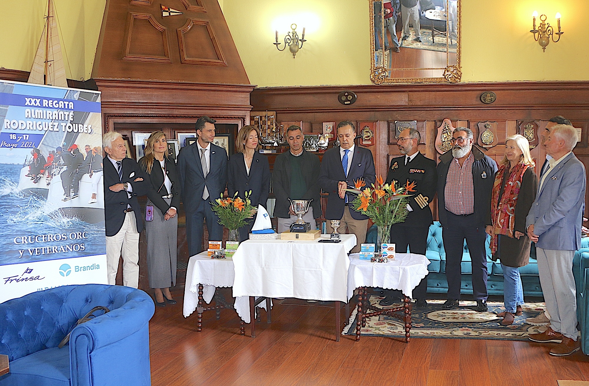 Autoridades civiles, militares y representantes del Real Club de Regatas Galicia durante la presentación oficial de la XXX Regata Trofeo Almirante Rodríguez-Toubes, celebrada en el salón noble de la entidad náutica vilagarciana.