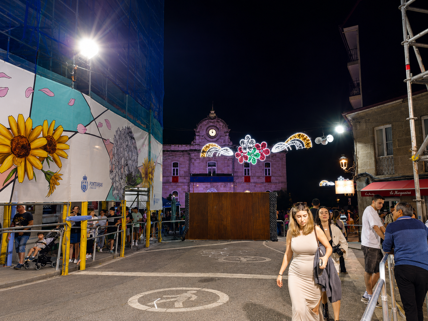 La Praza Maior de Ponteareas luce iluminada durante una de las noches festivas del municipio, con la Casa Consistorial al fondo y el montaje de la tradicional alfombra floral que cada año convierte a la villa en referente internacional del Corpus Christi.