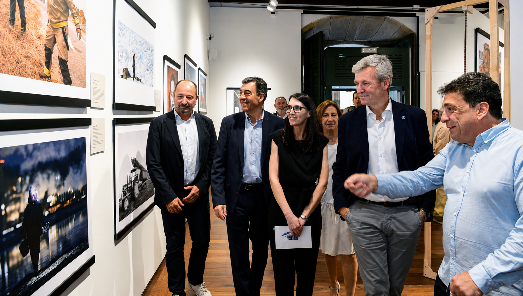 Autoridades e representantes da organización percorren a exposición “A Galicia inédita. Unha ollada diferente do fotoxornalismo galego”, inaugurada no Colexio de Fonseca, en Santiago de Compostela.