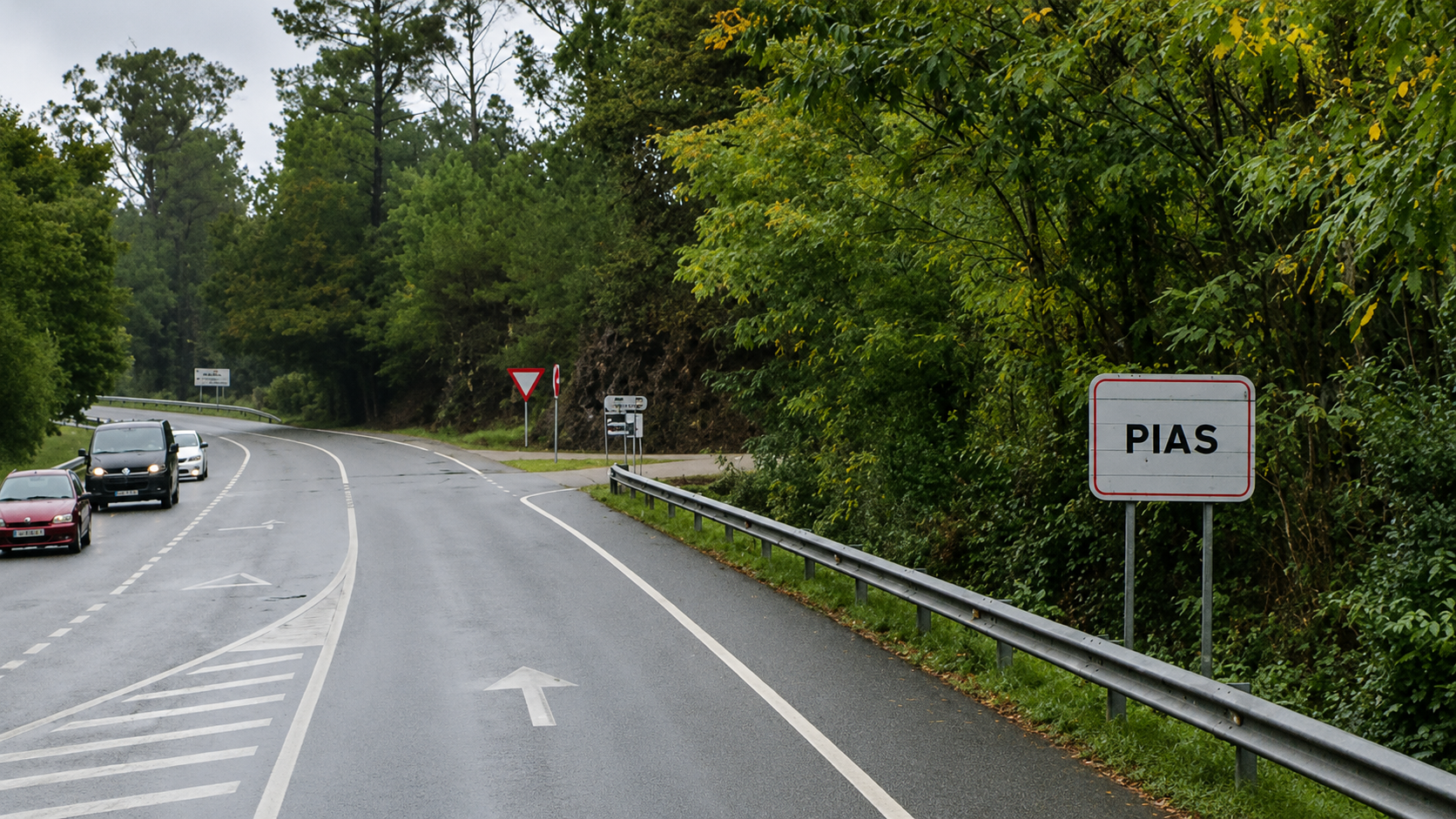 Cartel de entrada á parroquia de Pías, nunha estrada rodeada pola vexetación característica da contorna rural ponteareá.