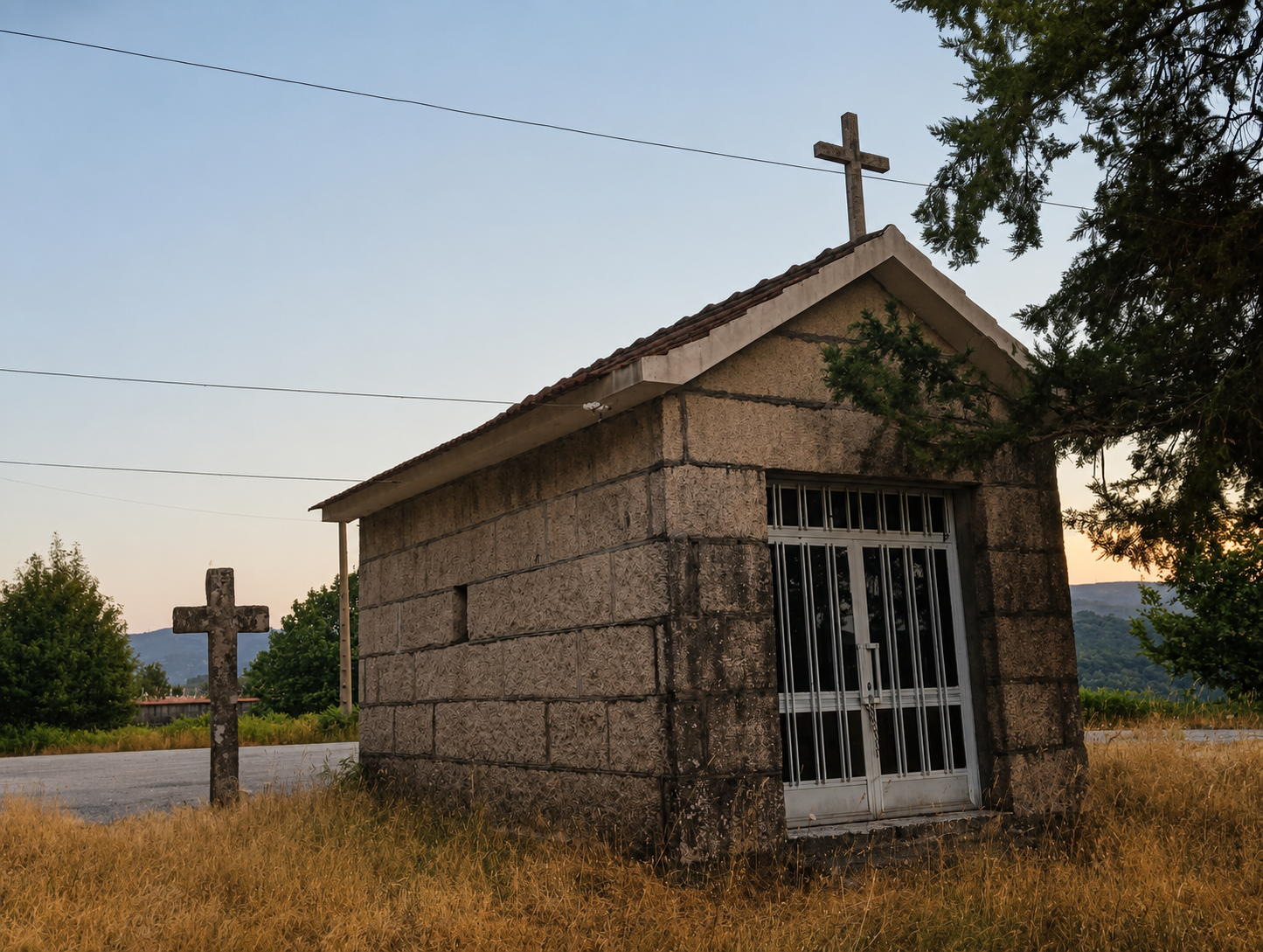 Capela do Carme, unha pequena construción de pedra coroada por unha cruz, integrada na paisaxe rural ao solpor.