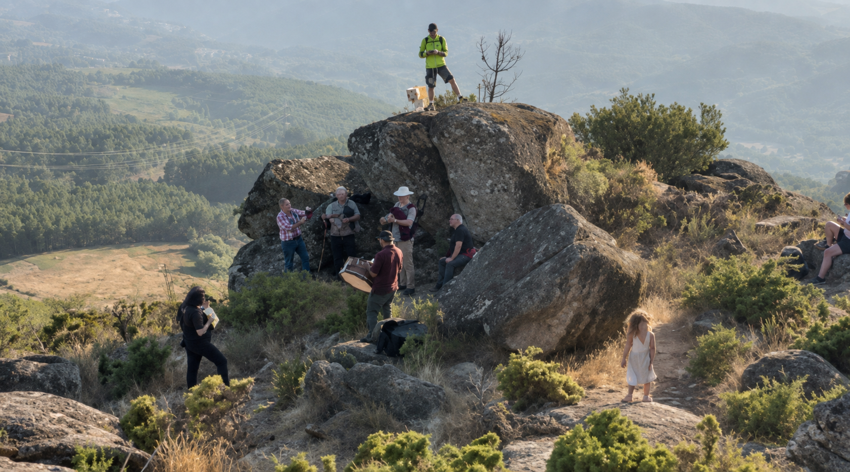 Familias y músicos se congregan entre las formaciones rocosas de la cumbre del Coto de Aldiri para compartir la espera y la contemplación del eclipse.