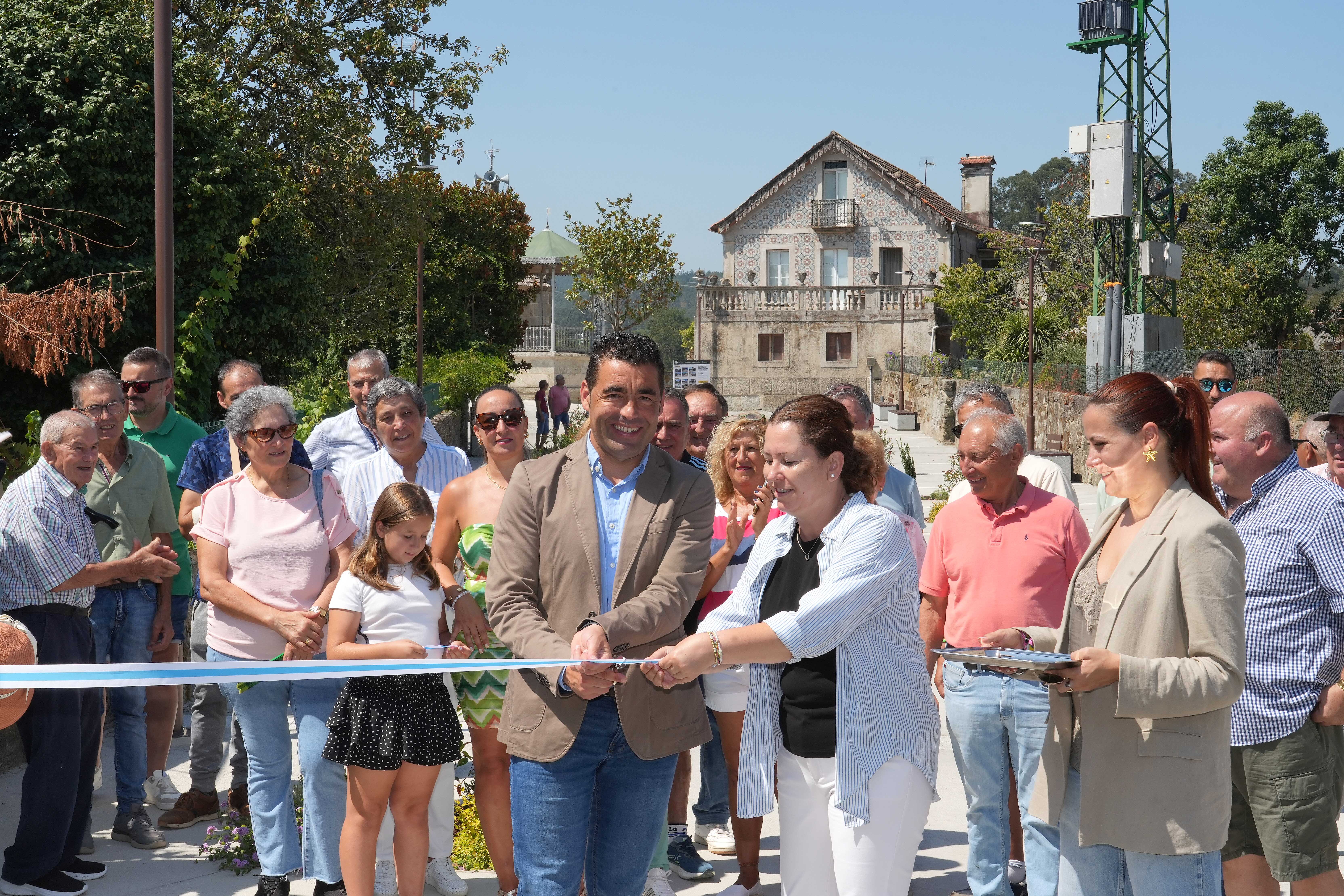 Luis López y Marta Valcárcel cortan la cinta inaugural de la renovada zona de Cabreira ante vecinos y representantes institucionales.