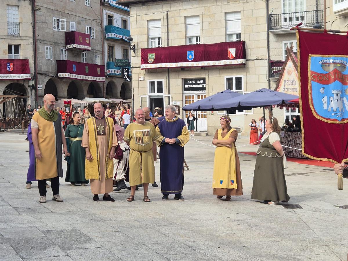 Participantes de la 37ª Festa da Istoria, con vestimentas de época, en uno de los espacios engalanados del conjunto histórico de Ribadavia durante la jornada central de la celebración.
