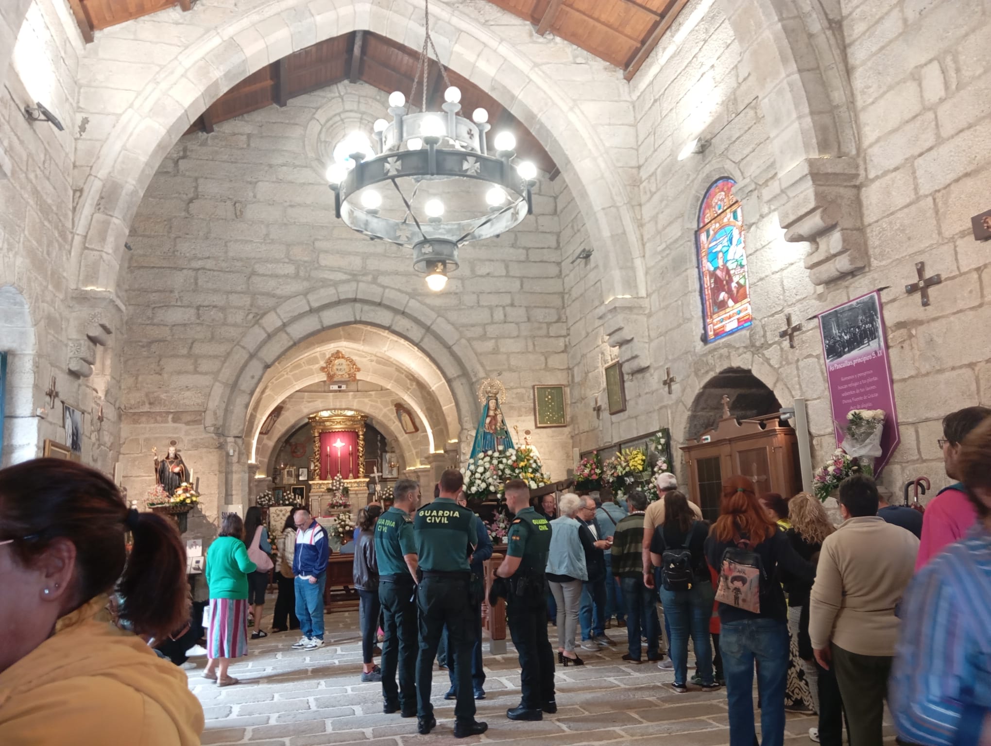 Fieles y visitantes aguardan en el interior del Santuario de A Franqueira junto a la imagen de la Virgen, en una jornada en la que la devoción volvió a llenar de vida este histórico templo de A Paradanta.